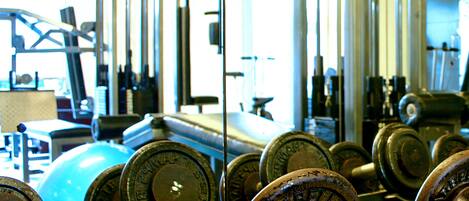 A gym with various exercise equipment, including dumbbells and weight plates.