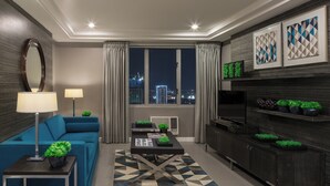 A modern living room with a sofa, coffee table, and a view of the city at night. - Astoria Plaza (Pasig)