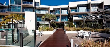 A modern building with multiple balconies and a central walkway.