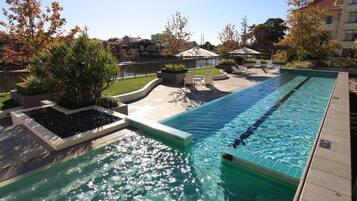 Relax by the serene pool surrounded by a patio with lounge chairs and planters.