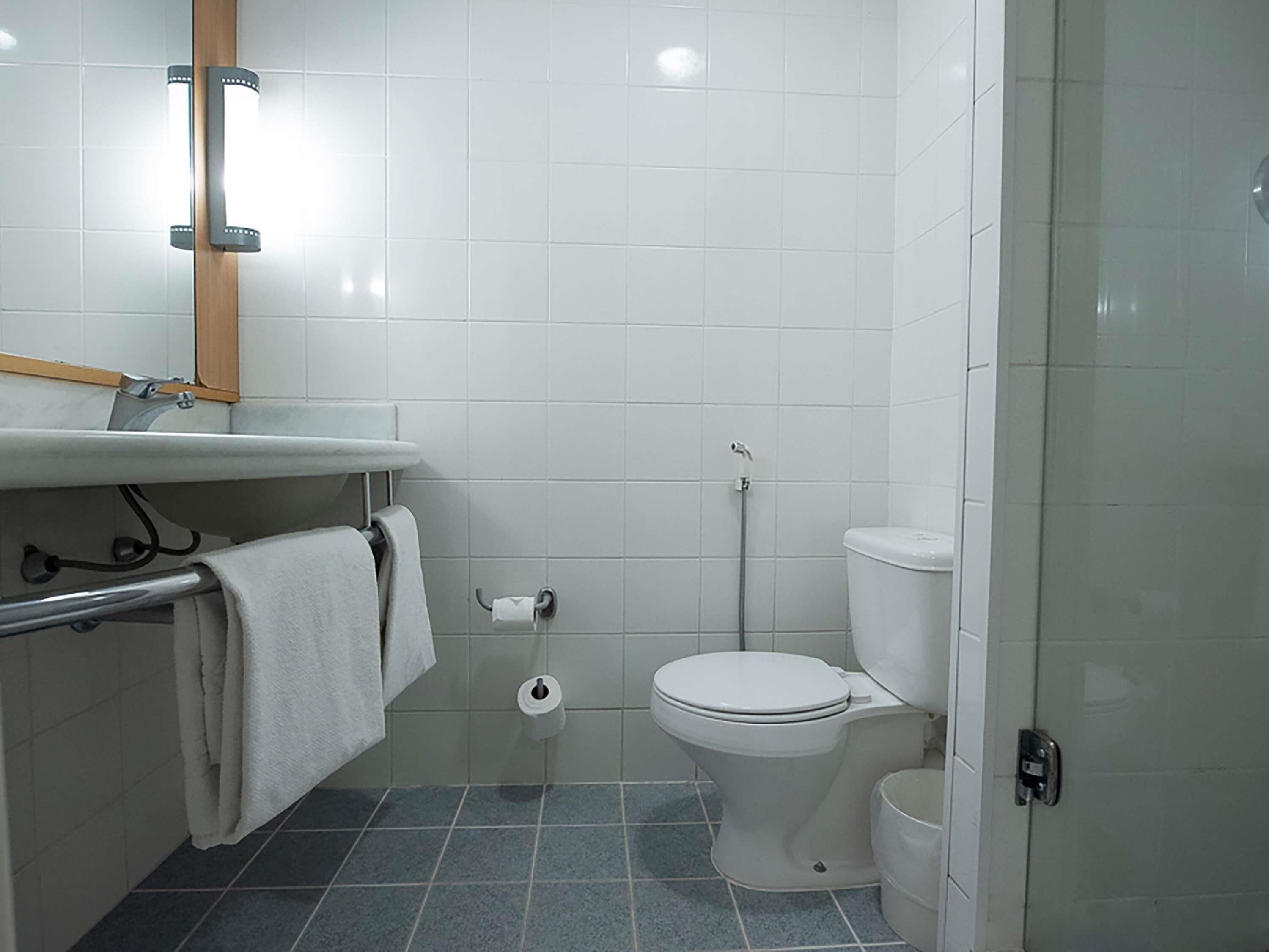 A bathroom with a toilet, sink, and shower.