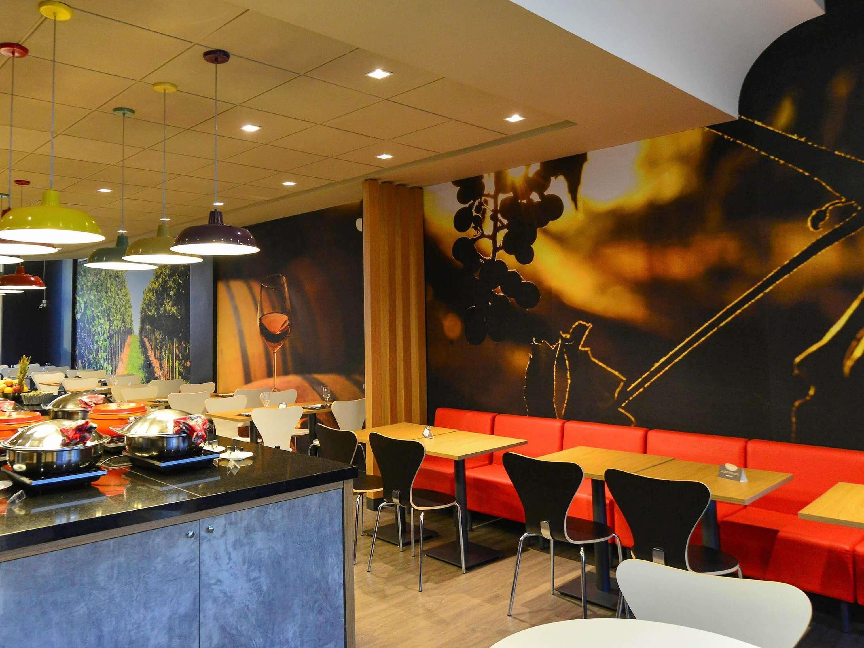 Un restaurante con barra central, cabinas y mesas.