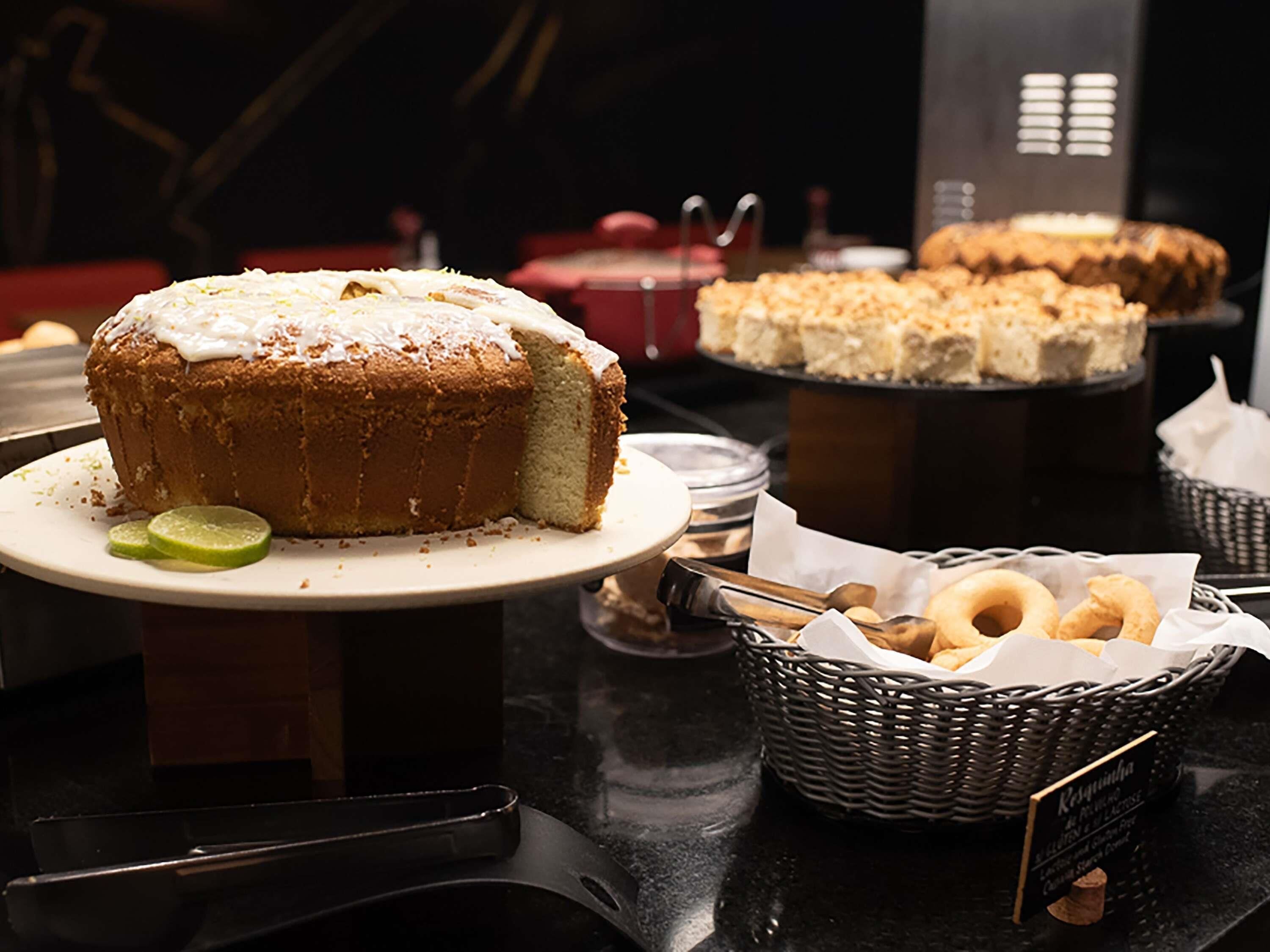 A buffet with a variety of desserts, including a cake with white icing and lime wedges on a plate.