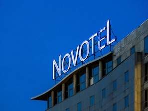 A hotel sign with the name 'NOVOTEL' against a clear blue sky. - Novotel Paris 13 Porte d'Italie (Le Kremlin-Bicetre)