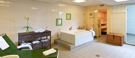 A bathroom with a bathtub, a green chair, a wooden cabinet, and a wicker basket.