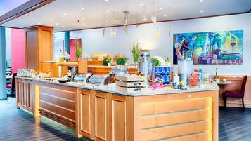 A modern breakfast bar with a variety of food items and a colorful mural on the wall.
