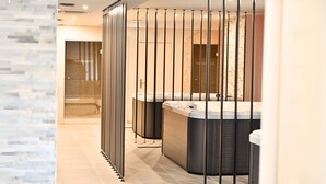 Un baño moderno con dos jacuzzis, una cabina de ducha de vidrio y suelo de baldosas.
