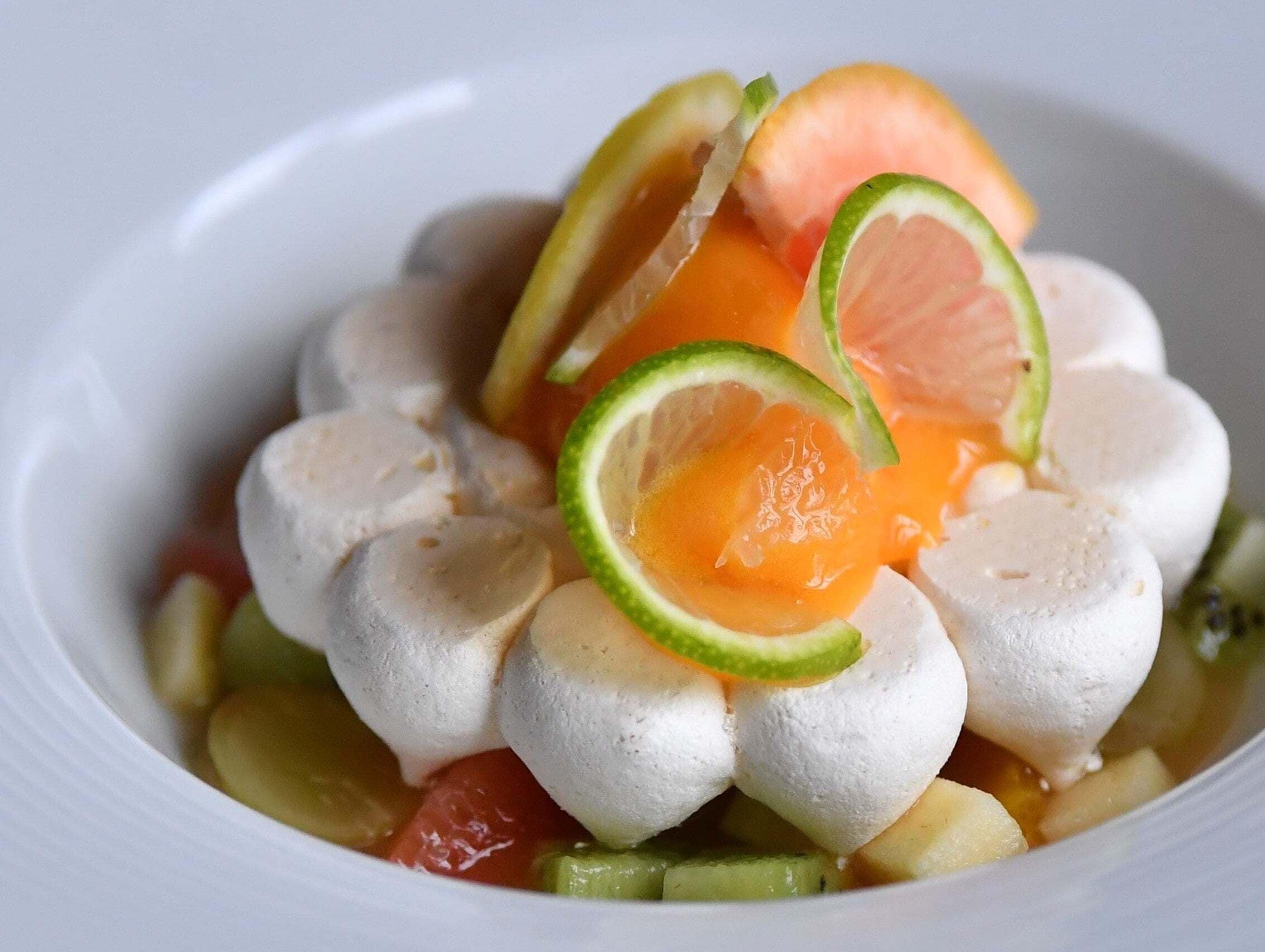 Eine Schüssel mit Speisen, darunter weiße Kugeln, Orangenscheiben und Limetten.