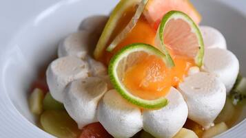 Eine Schüssel mit Speisen, darunter weiße Kugeln, Orangenscheiben und Limetten.
