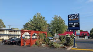 Un motel llamado Comox Valley Inn & Suites con un anuncio del café The Hen and Hog.