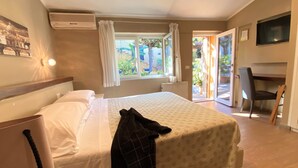 Una habitación de hotel con cama, escritorio y silla.