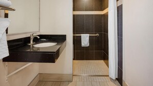 A modern bathroom with a black countertop sink, a mirror, and a shower area with a towel rack. - SureStay Hotel by Best Western San Rafael (San Rafael)