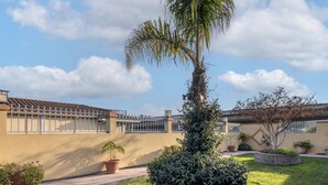 A residential area with a well-maintained lawn, a palm tree, and a house with a tiled roof and a metal fence. - SureStay Hotel by Best Western San Rafael (San Rafael)