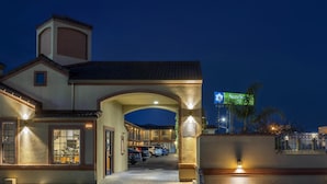 A hotel entrance with a covered driveway, a sign for 'SureSt Hotel', and a view of parked cars. - SureStay Hotel by Best Western San Rafael (San Rafael)
