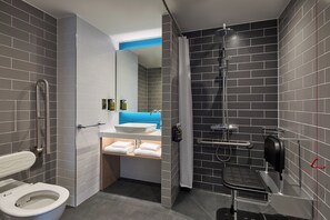 A modern bathroom with a toilet, sink, shower, and a towel rack. - Holiday Inn Express London - Limehouse by IHG (London)