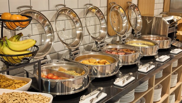 A buffet with various food items and utensils. - Holiday Inn Express London - Limehouse by IHG (London)