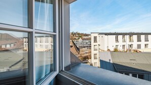 A view from a window overlooking a building with multiple floors and balconies. - Tailormade Hotel RÜDEN Schaffhausen (Schaffhausen)