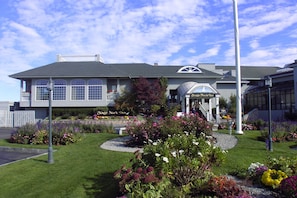 A hotel with a large sign reading "Stage Neck Inn," surrounded by well-maintained gardens and a clear sky. - Stage Neck Inn (York Harbor)