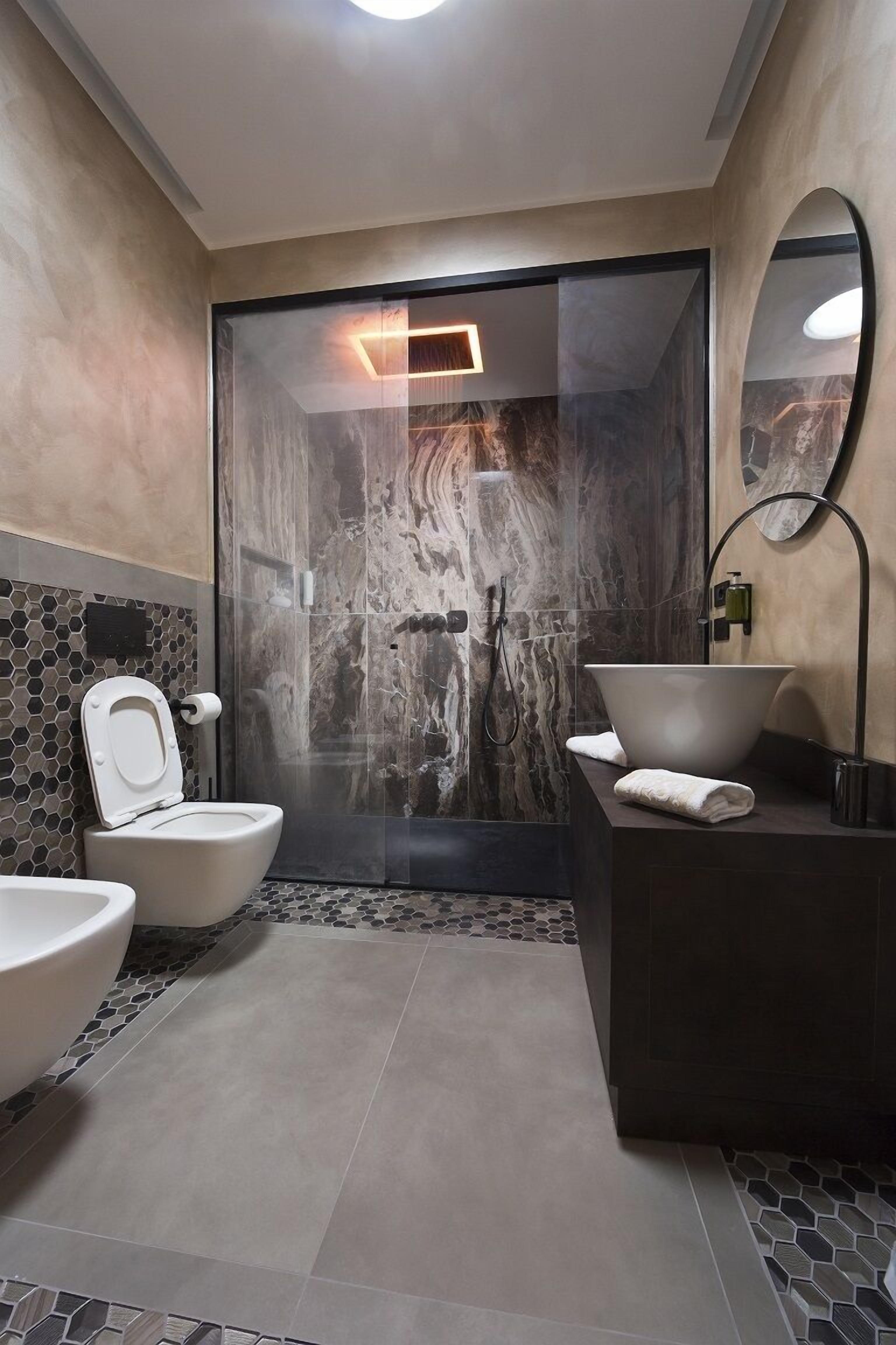 A modern bathroom with a toilet, bidet, and large sink.