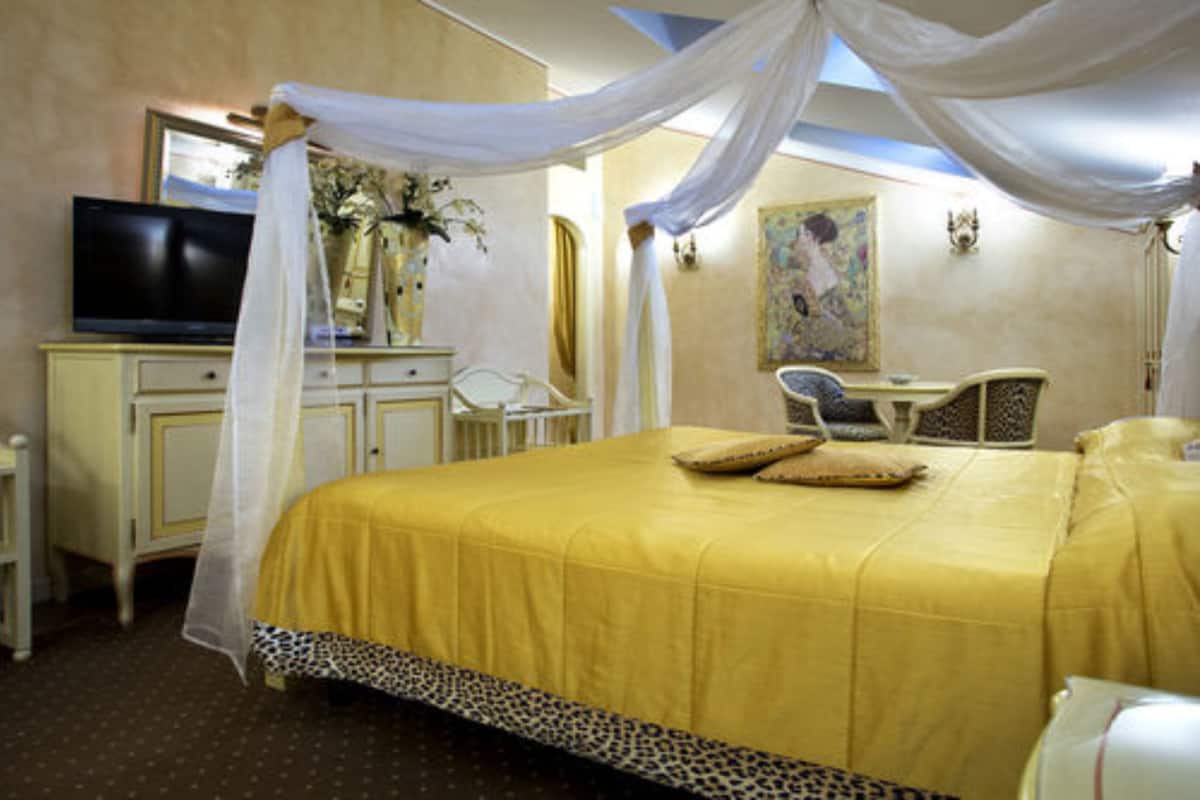 A hotel room with a bed, a television, a desk, and a chair.