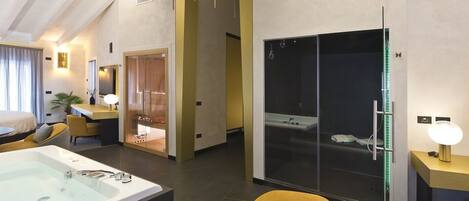 A modern hotel room with a large bathtub, a separate shower area, a dining area, and a cozy seating space.