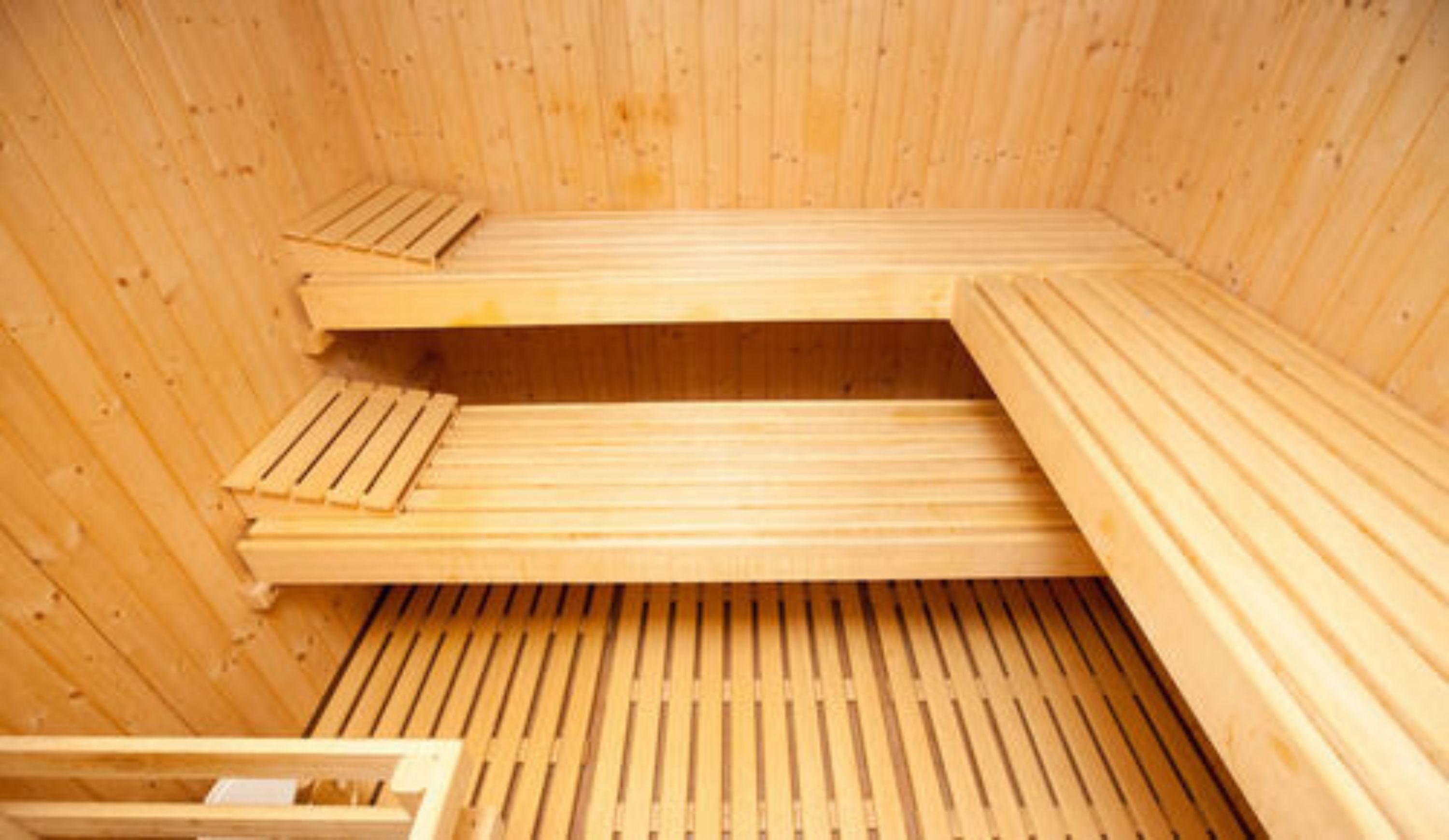 Una sauna con bancos de madera y suelo de listones.