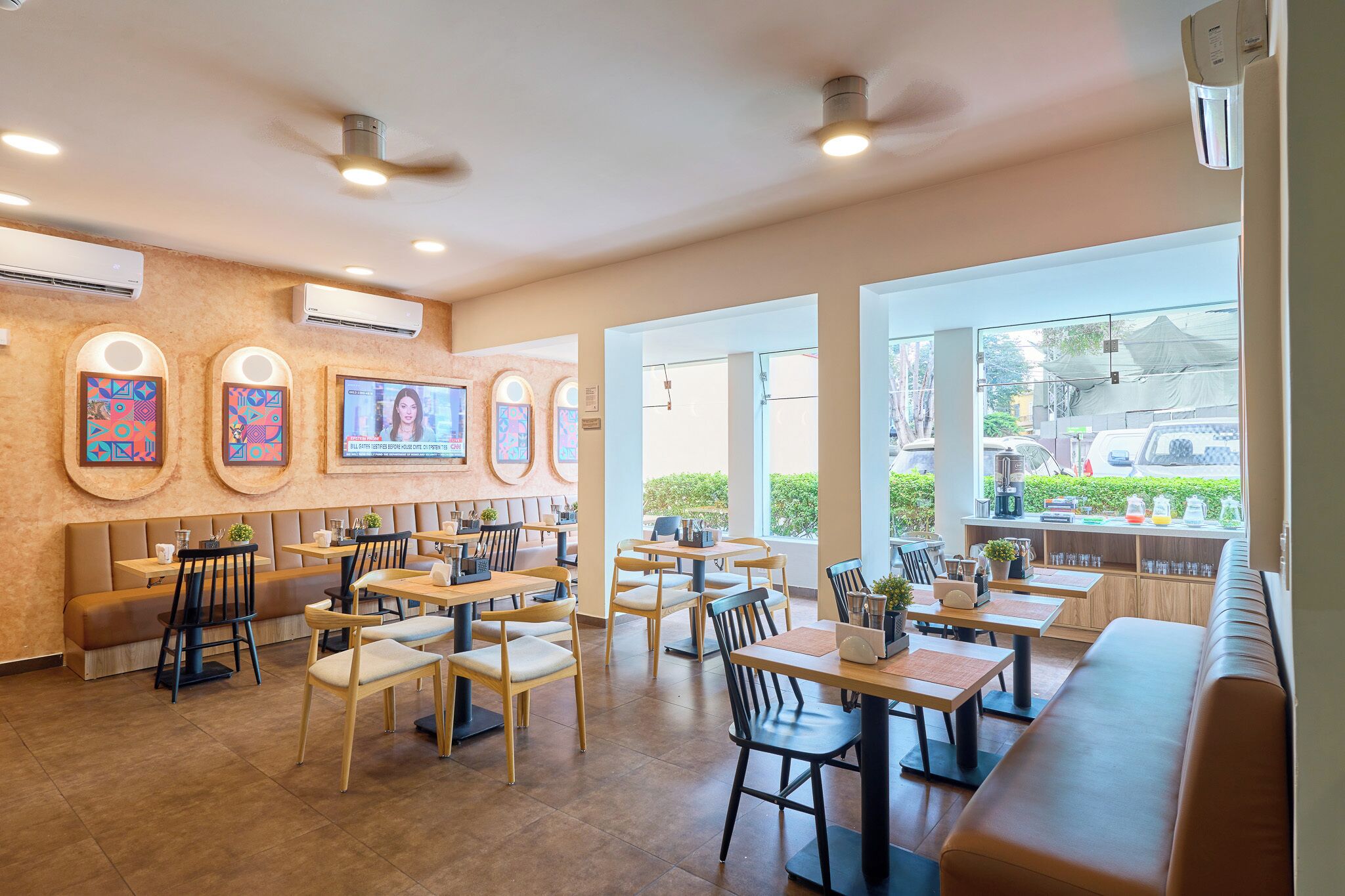 A restaurant with multiple seating areas, including booths and tables, and large windows providing a view of the outside.