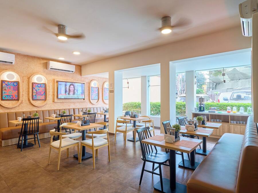 A restaurant with multiple seating areas, including booths and tables, and large windows providing a view of the outside.