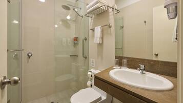A modern bathroom with a glass-enclosed shower, a white toilet, a sink with a marble countertop, and a towel rack.
