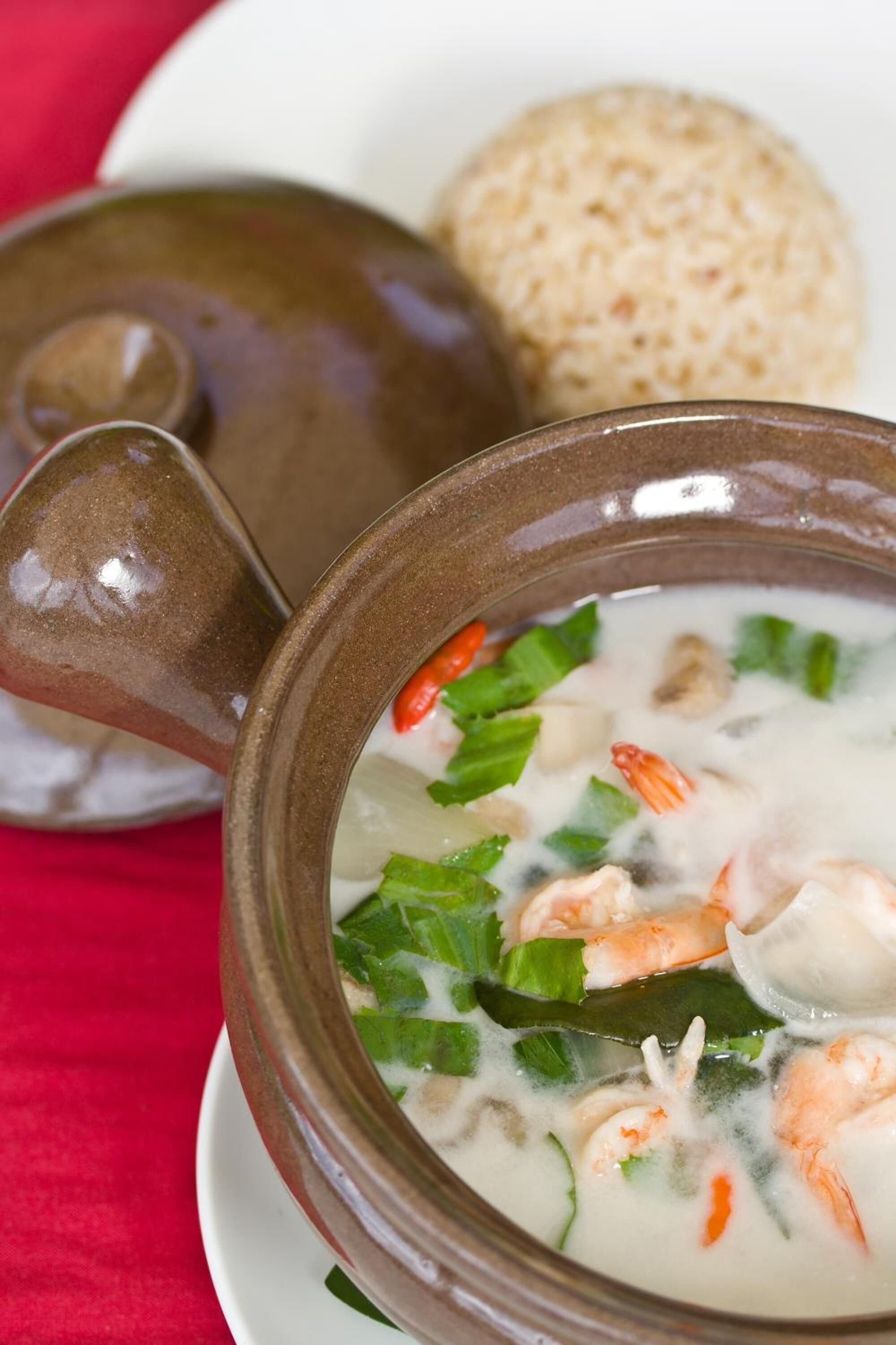 Un bol de soupe aux crevettes et aux légumes, accompagné d’un bol de riz et d’une théière.