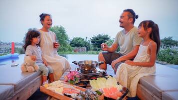 Enjoy a family meal on an outdoor deck with a serving tray and portable stove.