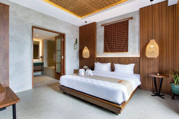 Una habitación de hotel moderna con una cama grande, paneles de madera, un techo con un diseño geométrico y dos lámparas fijadas a la pared.