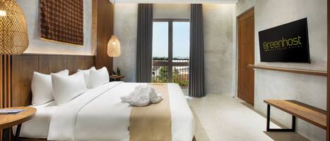 A modern hotel room with a large bed, a TV mounted on the wall, and a view of the outdoors through the window.