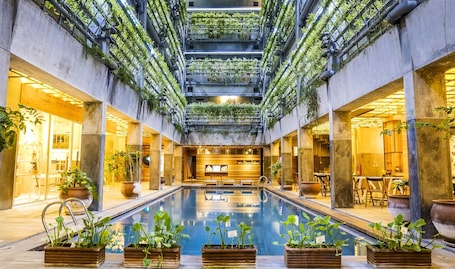 Una piscina al aire libre, sillones reclinables de piscina