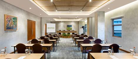 A conference room with tables, chairs, a projector screen, and a large window.