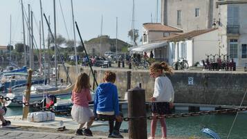 Una zona ribereña con barcos amarrados, un muro de piedra y edificios con balcones.