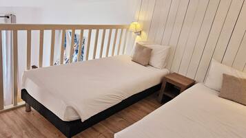Ein Schlafzimmer mit Bett, Nachttischen und Blick durch ein Fenster.