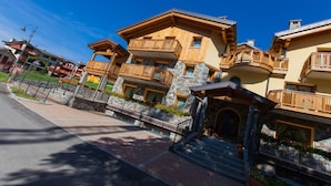 Um hotel com vários andares, varandas, fachada de pedra e céu claro.