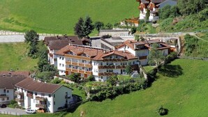 Un hotel a più piani con balconi, affacciato su una collina con vista sul paesaggio circostante.