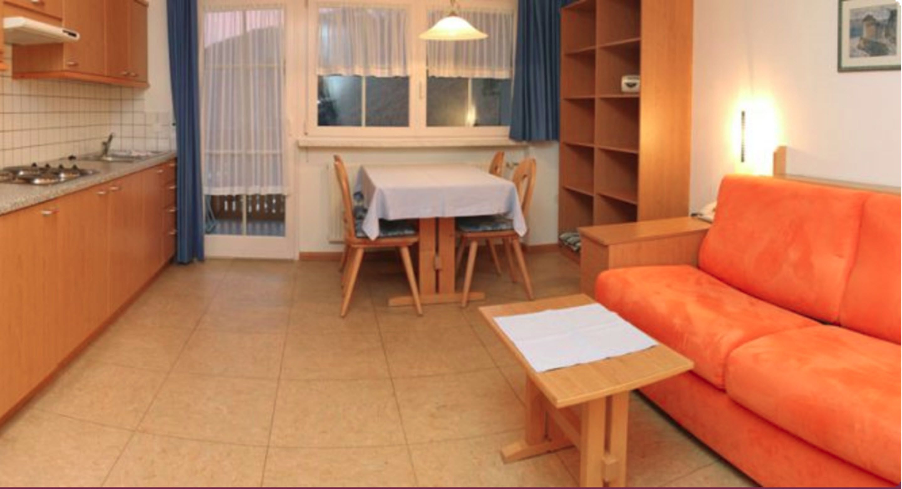 A compact living space with a kitchen, dining area, and a sofa.