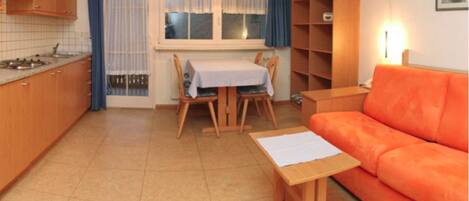 A compact living space with a kitchen, dining area, and a sofa.