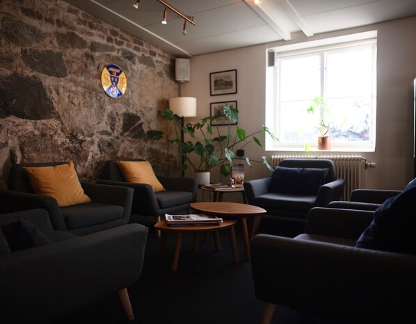 Una sala de estar acogedora con una pared de piedra, un ventanal con vistas y muebles modernos.