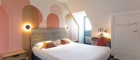 A bedroom with a bed, bedside tables, a desk, and a chair.