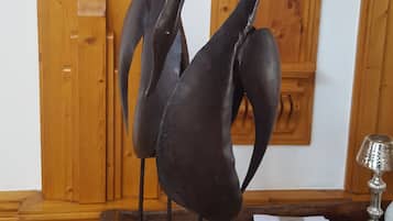 Ein Holztisch mit einer Skulptur, einer Lampe und einer Wandleuchte.