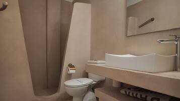 A modern bathroom with a toilet, sink, and shower.