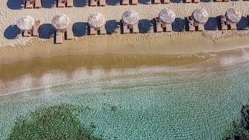 On the beach, white sand, sun loungers, beach umbrellas