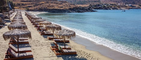 On the beach, white sand, sun loungers, beach umbrellas