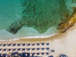 On the beach, white sand, sun-loungers, beach umbrellas