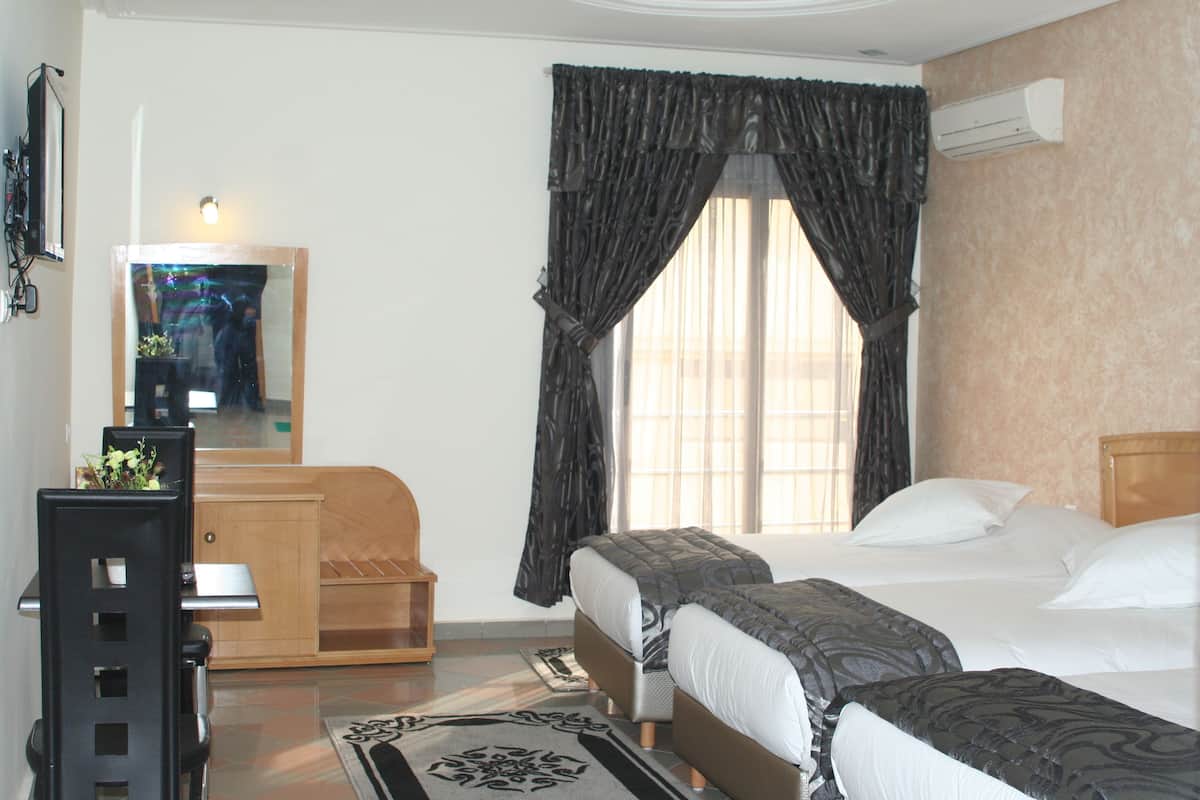 Deluxe Triple Room | Minibar, in-room safe, desk, blackout drapes