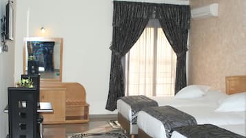 Deluxe Triple Room | Minibar, in-room safe, desk, blackout drapes